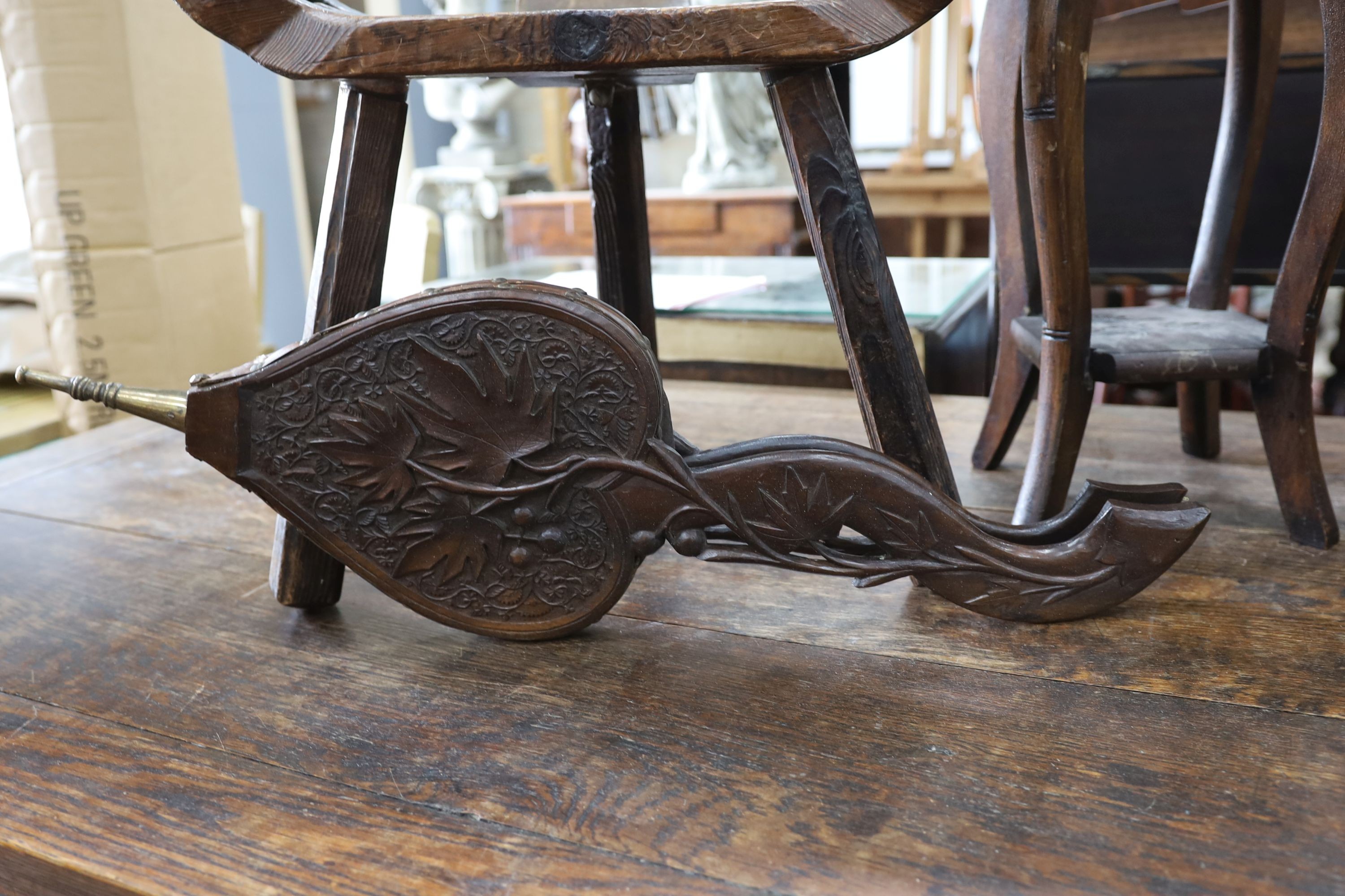 A small child's oak rocking chair, a pair of carved wood bellows and two caned tables